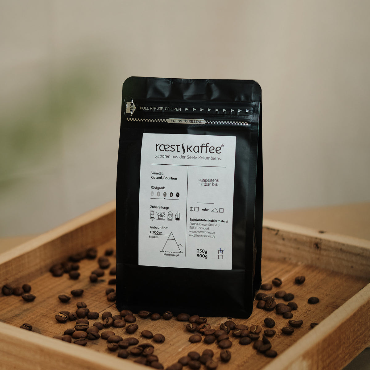 Eine 250g Kaffeepackung auf einem Holzbrett. Eine 250g Kaffeepackung auf einem Holzbrett. Mit Aromen von sonnengereifter Orange, Schokolade und Nüssen