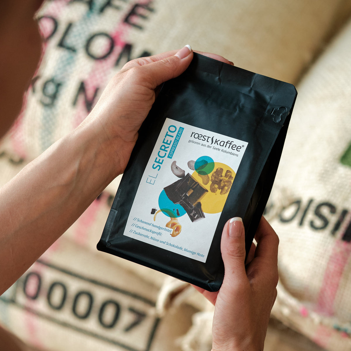 Eine Frau hält eine 250g Kaffeepackung in der Hand 