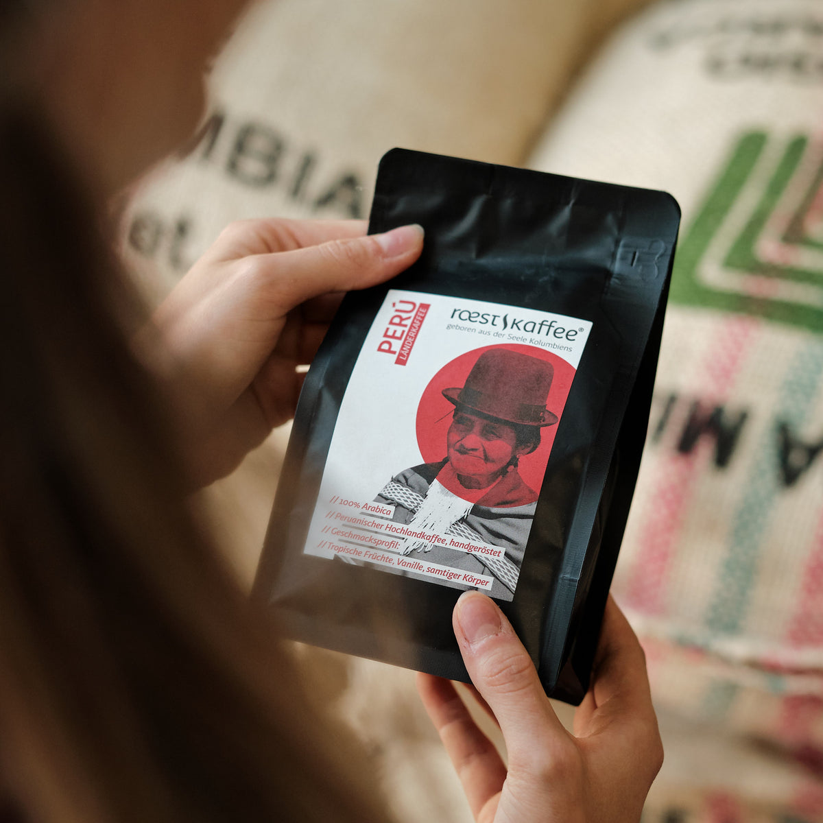 Eine Frau hält eine 250g Kaffeepackung in der Hand 
